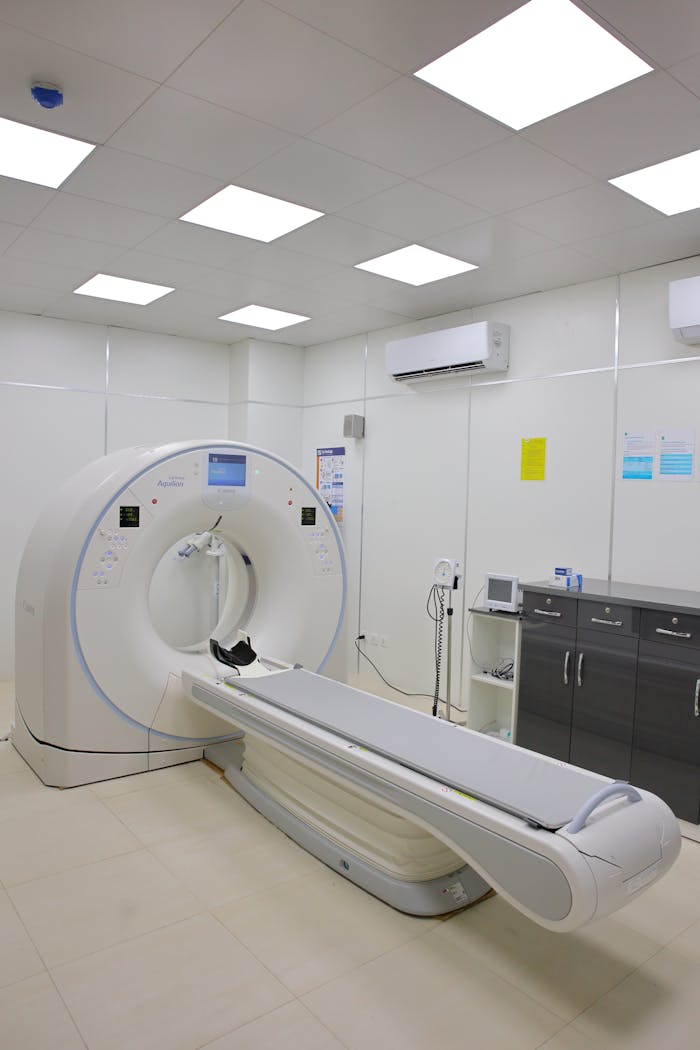 High-tech CT scanner in a bright, well-equipped hospital room for medical diagnostics.